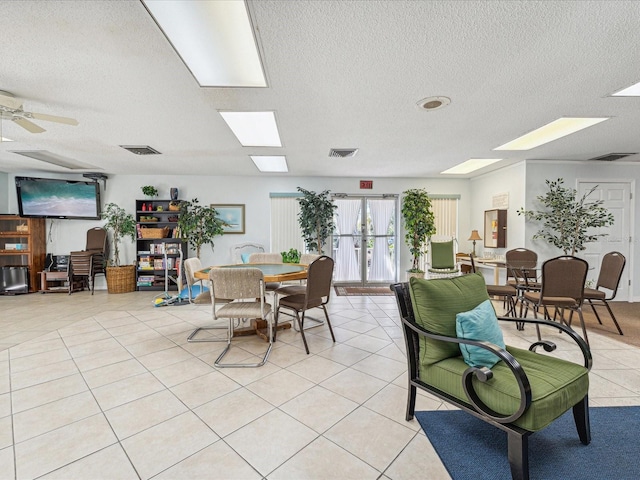 dining space featuring ceiling fan, light tile patterned floors, and a textured ceiling