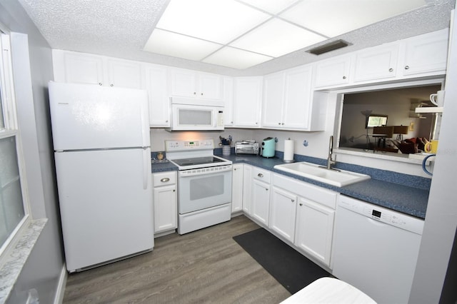 kitchen with sink, white cabinetry, white appliances, dark hardwood / wood-style floors, and a drop ceiling