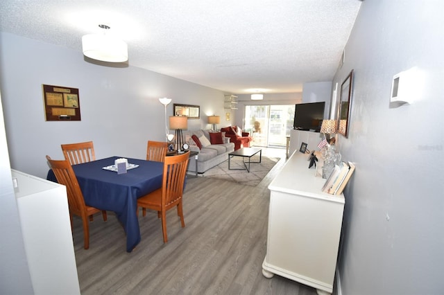 dining area featuring hardwood / wood-style floors and a textured ceiling