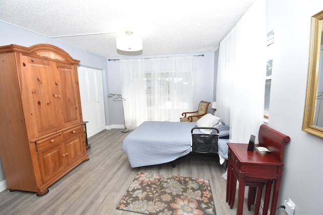 bedroom with light hardwood / wood-style floors and a textured ceiling