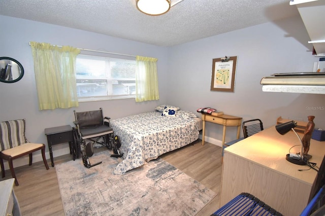 bedroom with light wood-type flooring and a textured ceiling