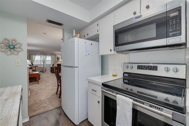 kitchen featuring white cabinets, appliances with stainless steel finishes, and dark colored carpet