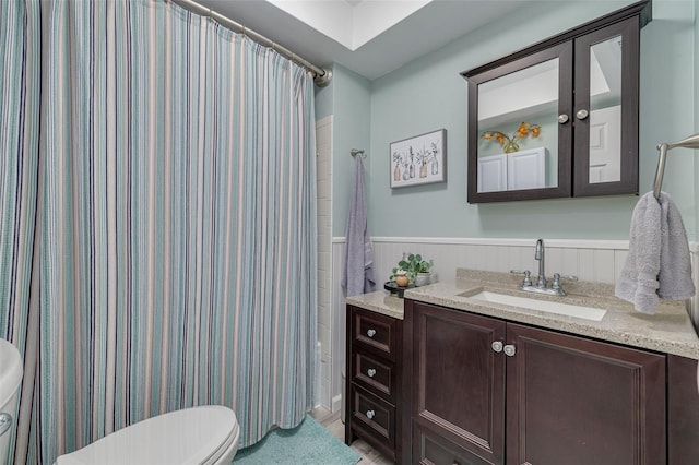 bathroom featuring curtained shower, toilet, vanity, and wooden walls