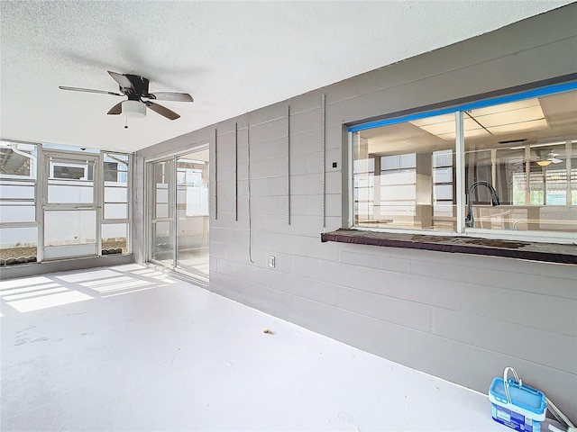 empty room with ceiling fan, concrete flooring, sink, and a textured ceiling