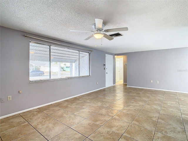 tiled spare room with ceiling fan and a textured ceiling