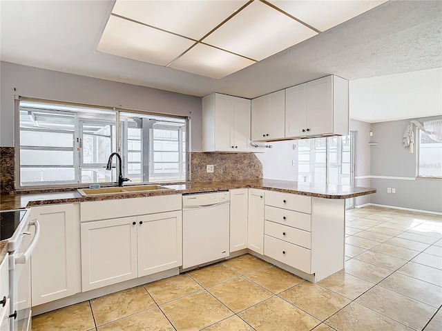 kitchen with sink, white cabinetry, white dishwasher, kitchen peninsula, and stove