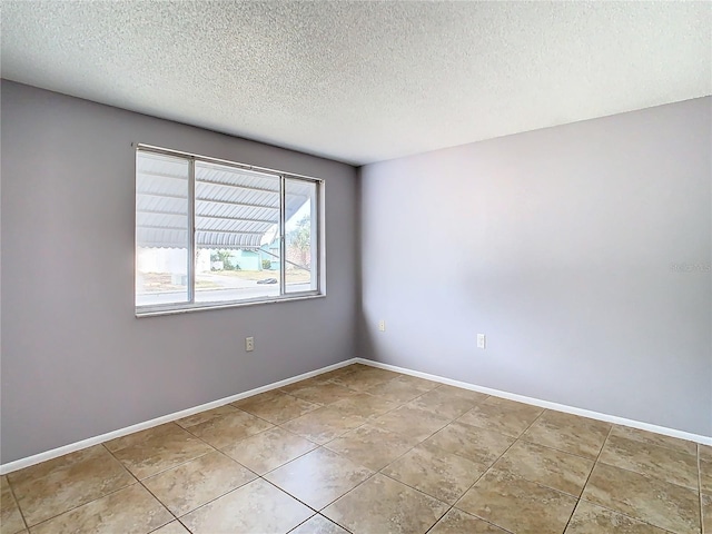 tiled spare room featuring a textured ceiling