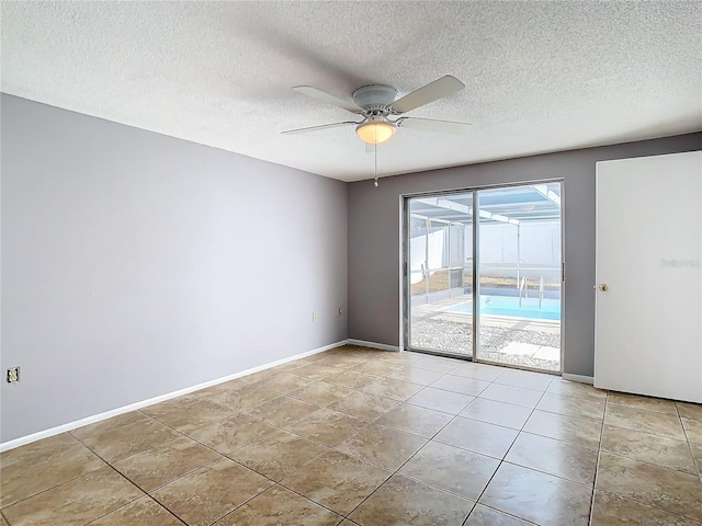 empty room featuring a textured ceiling, ceiling fan, and light tile patterned flooring