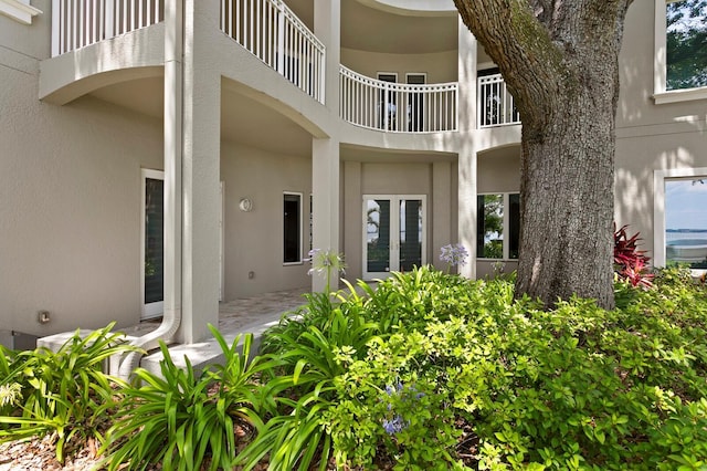 property entrance featuring stucco siding and french doors