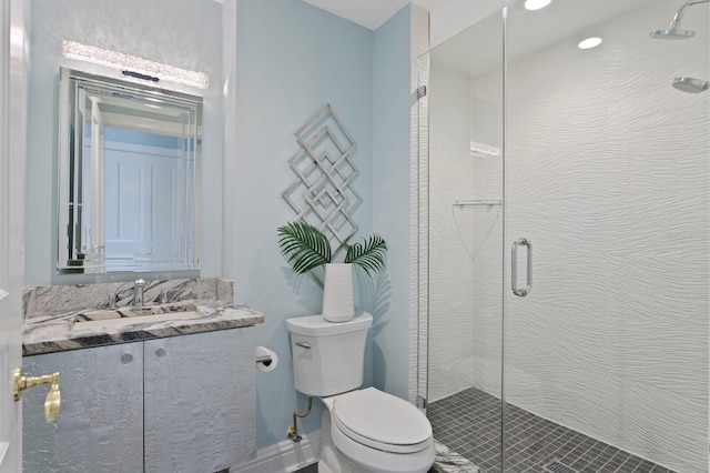 bathroom with vanity, a shower with shower door, and toilet