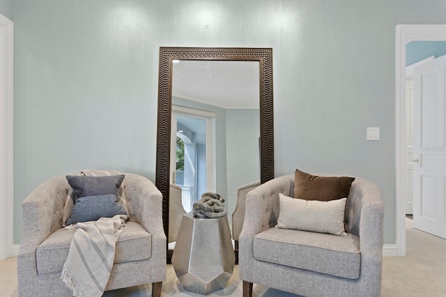 living area featuring baseboards and light carpet