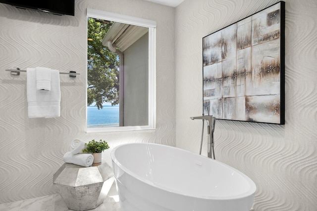 full bath featuring a soaking tub and a healthy amount of sunlight