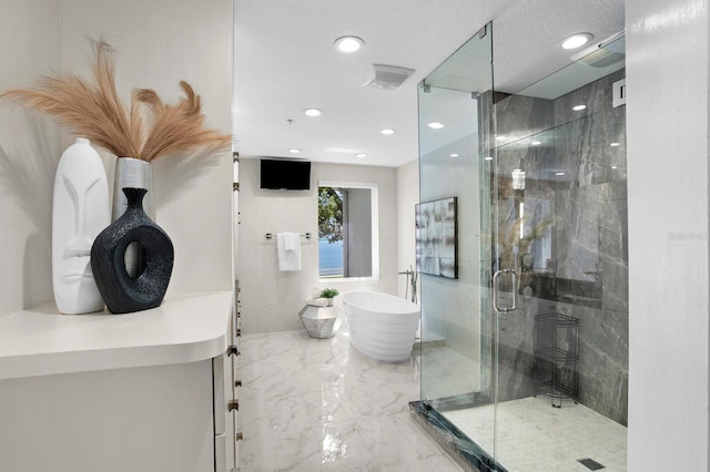 bathroom with a shower stall, recessed lighting, a soaking tub, marble finish floor, and a textured ceiling