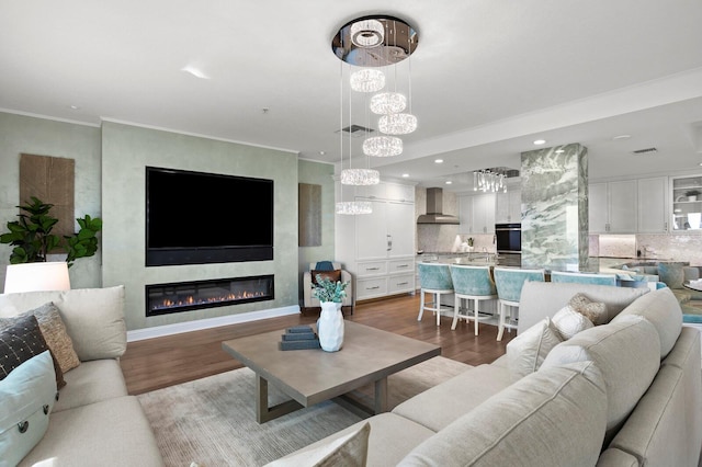 living room with recessed lighting, a large fireplace, wood finished floors, and ornamental molding