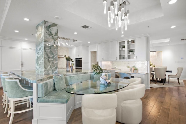 dining area with visible vents, recessed lighting, a raised ceiling, and dark wood-style flooring