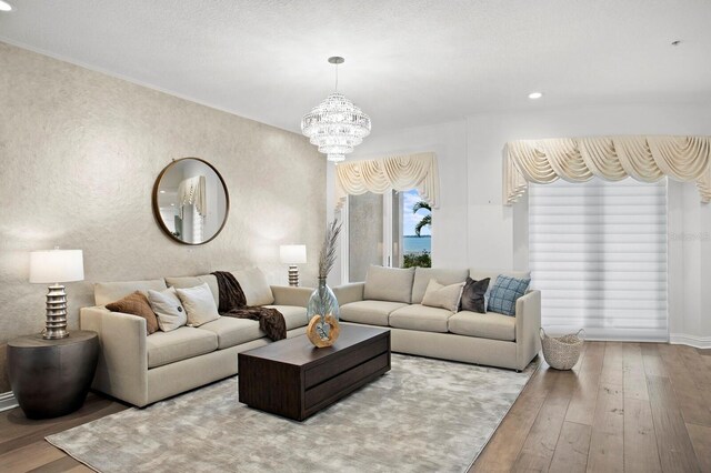 living room with hardwood / wood-style flooring, a notable chandelier, recessed lighting, and baseboards