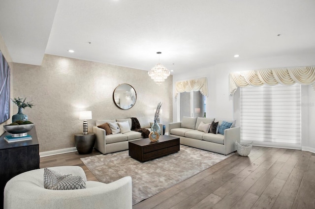 living area with recessed lighting, baseboards, an inviting chandelier, and wood finished floors