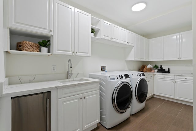 clothes washing area with a sink, cabinet space, separate washer and dryer, and dark tile patterned floors