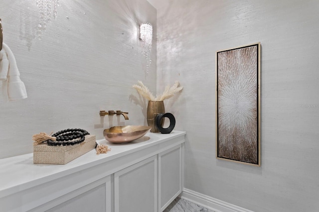 bathroom with vanity, baseboards, and marble finish floor