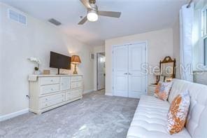 carpeted living room with ceiling fan