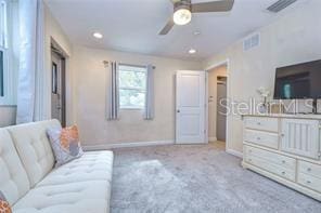 carpeted living room featuring ceiling fan