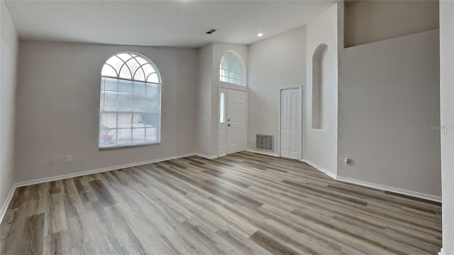 foyer with a high ceiling and light wood-type flooring