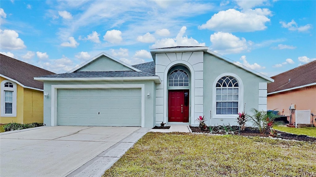 view of front of house with a garage and a front lawn