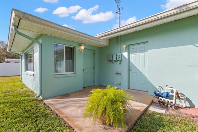 view of exterior entry with a yard