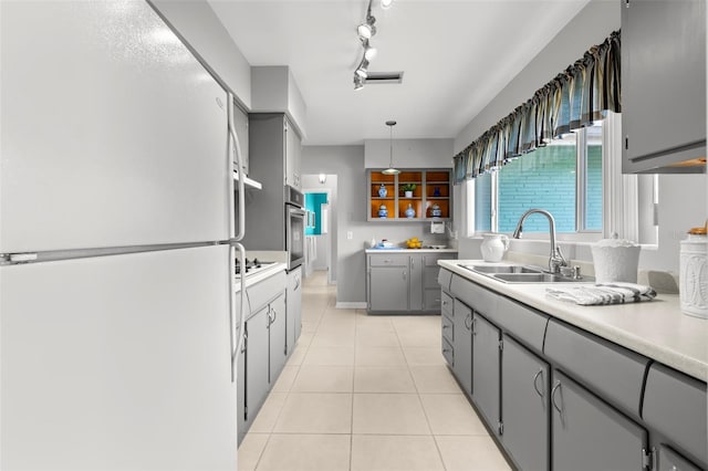 kitchen with gray cabinetry, light tile patterned floors, white appliances, and decorative light fixtures