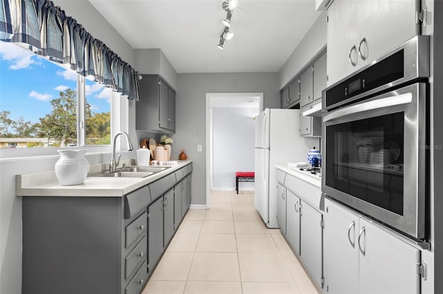 kitchen featuring light tile patterned floors, sink, and gray cabinetry