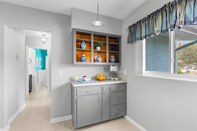 kitchen featuring light tile patterned flooring, pendant lighting, and gray cabinetry