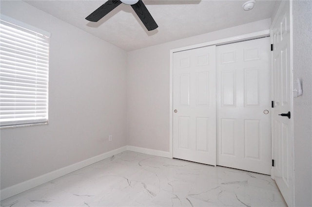 unfurnished bedroom featuring ceiling fan and a closet