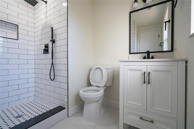 bathroom featuring a tile shower, toilet, and vanity