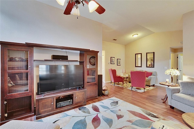 living room with ceiling fan, lofted ceiling, and light hardwood / wood-style floors