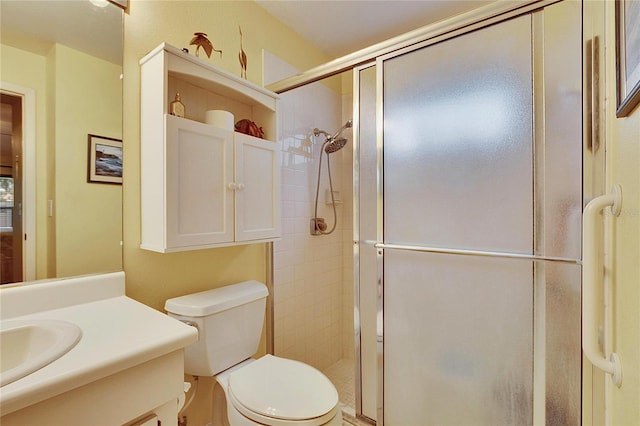 bathroom with vanity, toilet, and a shower with door