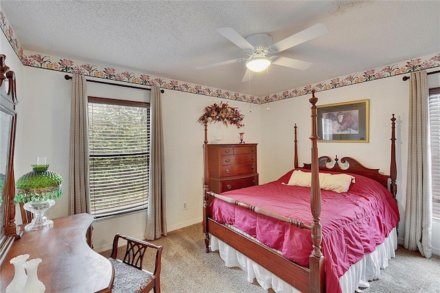 carpeted bedroom featuring ceiling fan and a textured ceiling