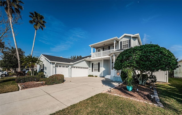 view of property featuring a garage, a balcony, and a front lawn