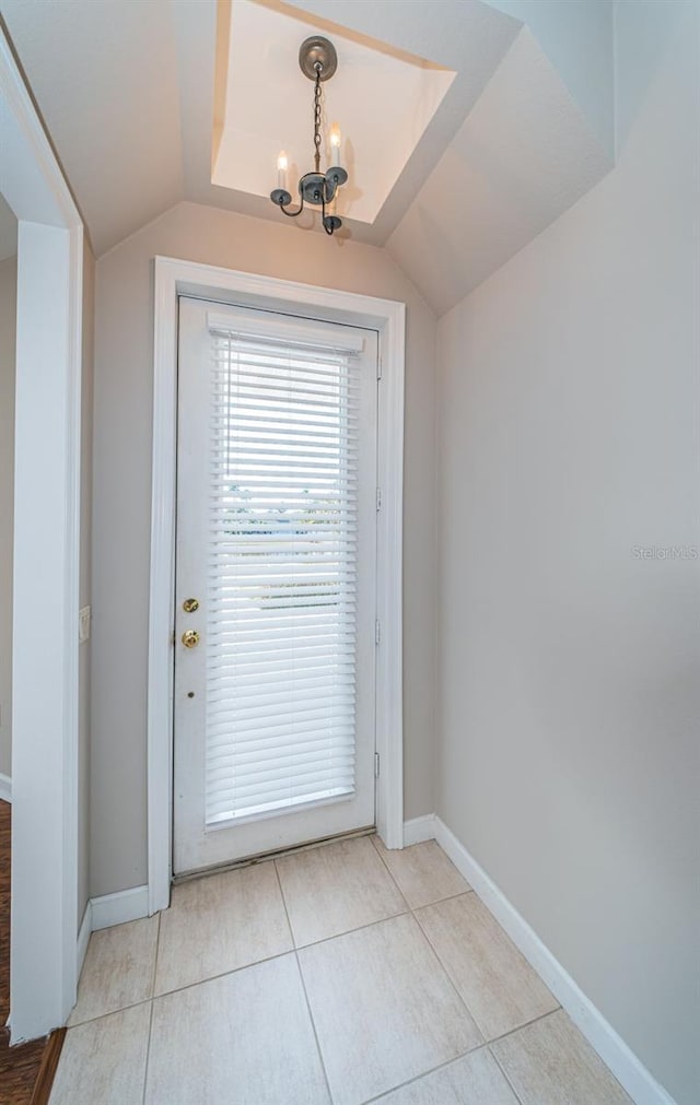 entryway with an inviting chandelier, vaulted ceiling, and light tile patterned floors