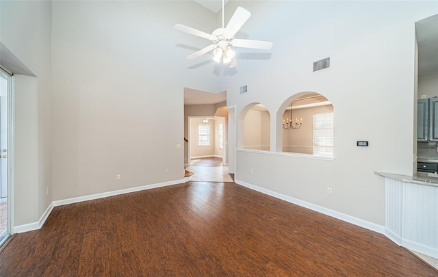 spare room with wood-type flooring, ceiling fan with notable chandelier, and high vaulted ceiling