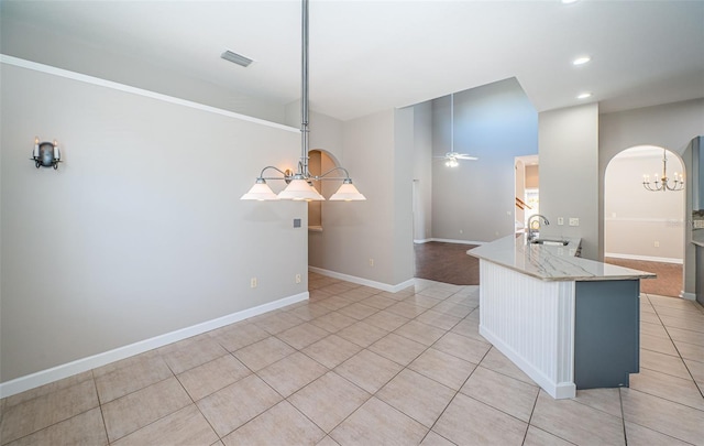 kitchen featuring sink, light tile patterned floors, ceiling fan, hanging light fixtures, and kitchen peninsula