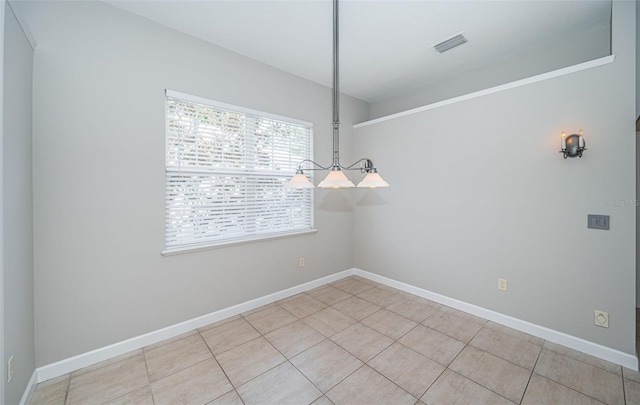 unfurnished dining area featuring light tile patterned flooring and a chandelier