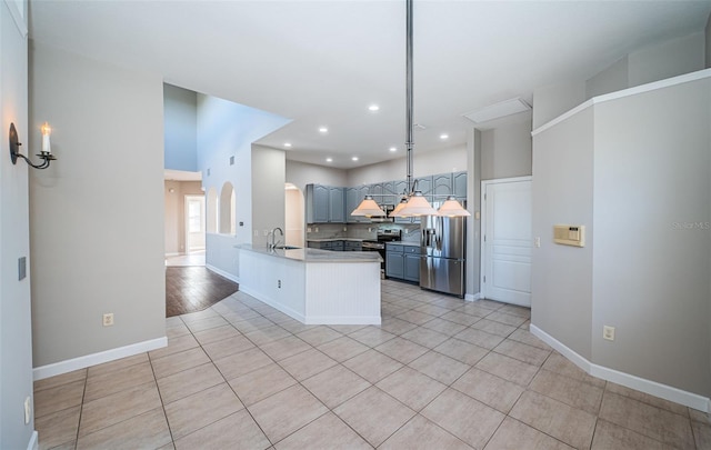 kitchen featuring appliances with stainless steel finishes, kitchen peninsula, sink, and light tile patterned floors