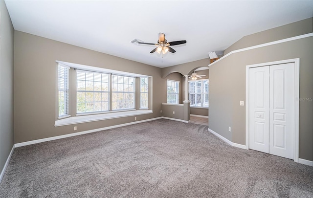 unfurnished bedroom with lofted ceiling, a closet, ceiling fan, and carpet flooring