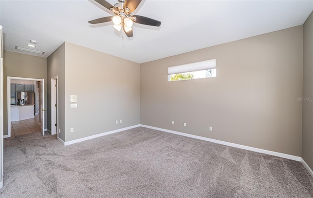 carpeted spare room with ceiling fan