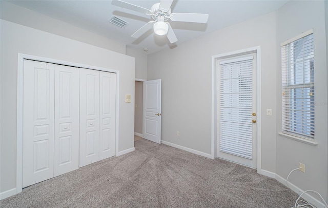 unfurnished bedroom featuring light colored carpet, ceiling fan, and a closet