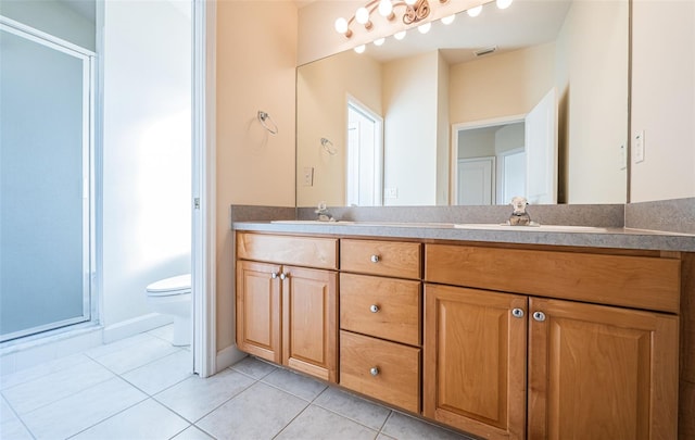 bathroom with tile patterned floors, toilet, a shower with shower door, and vanity