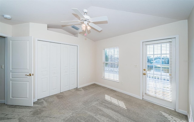 unfurnished bedroom with ceiling fan, access to exterior, light carpet, vaulted ceiling, and a closet