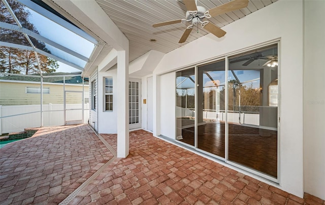 view of patio with ceiling fan and glass enclosure