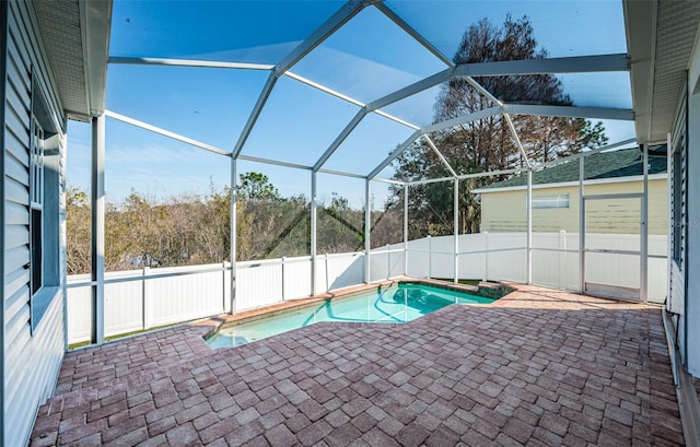 view of swimming pool featuring a patio and glass enclosure