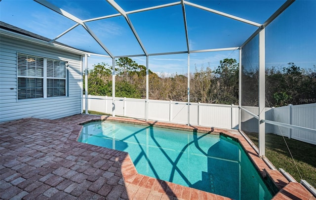 view of swimming pool featuring a patio area and glass enclosure